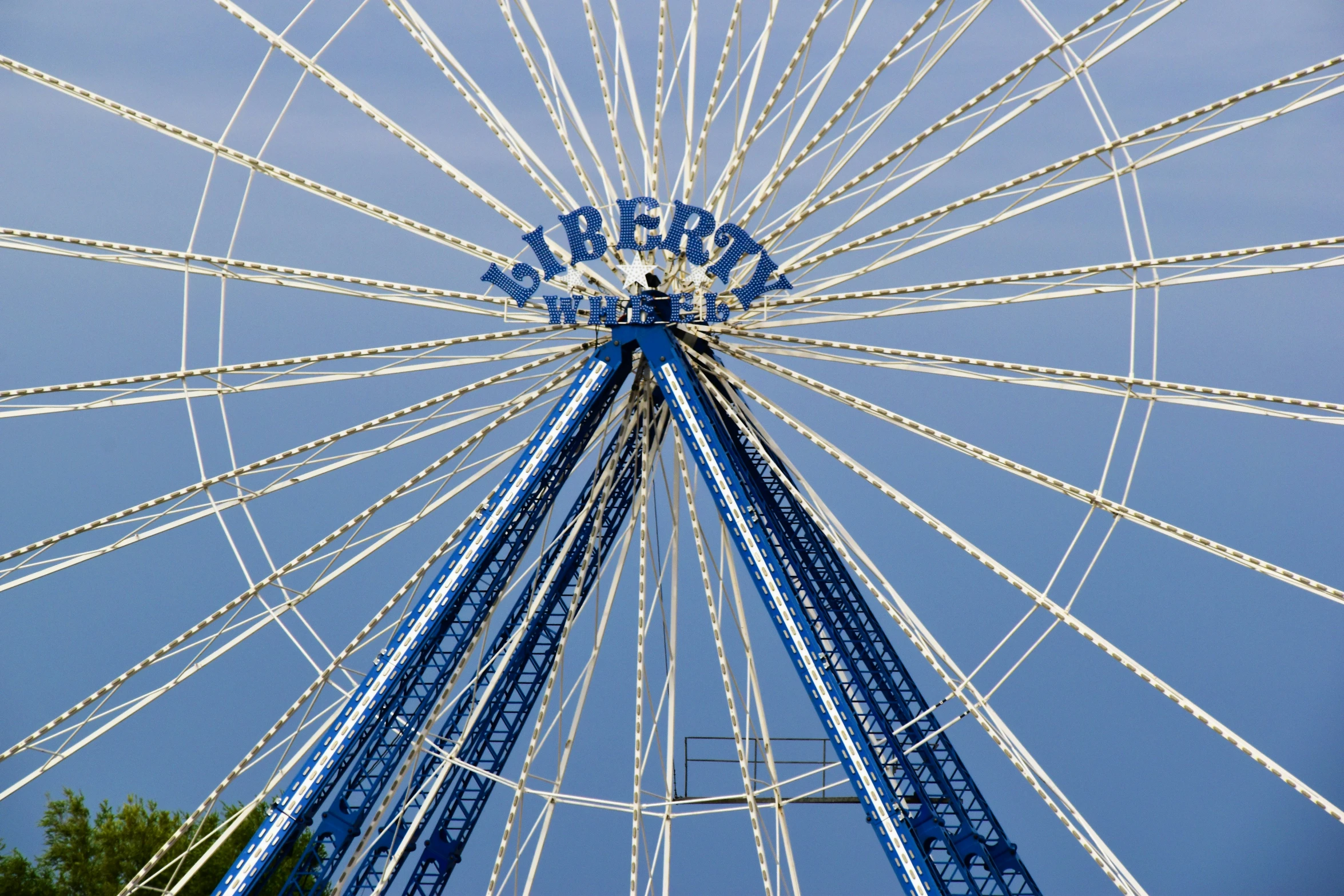 the large ferris wheel sits under a blue sky
