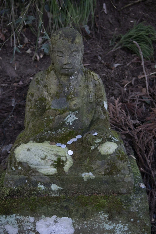 a statue sitting on top of a stone slab