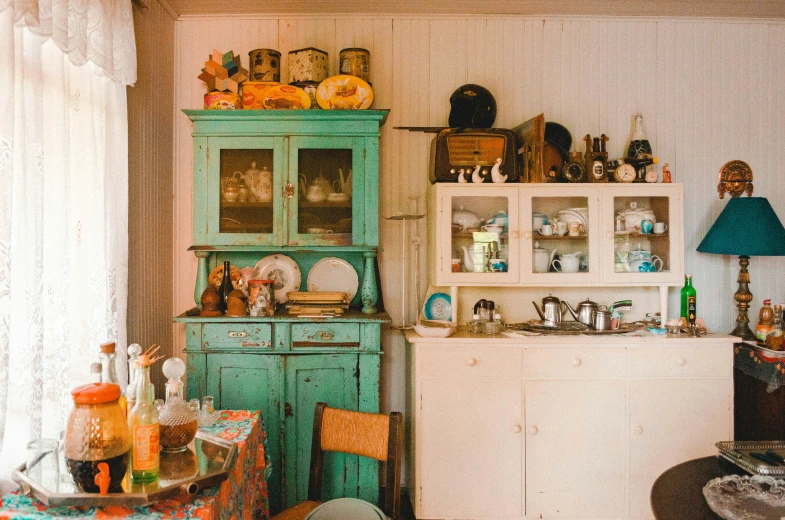 the corner of a small kitchen with a green cabinet