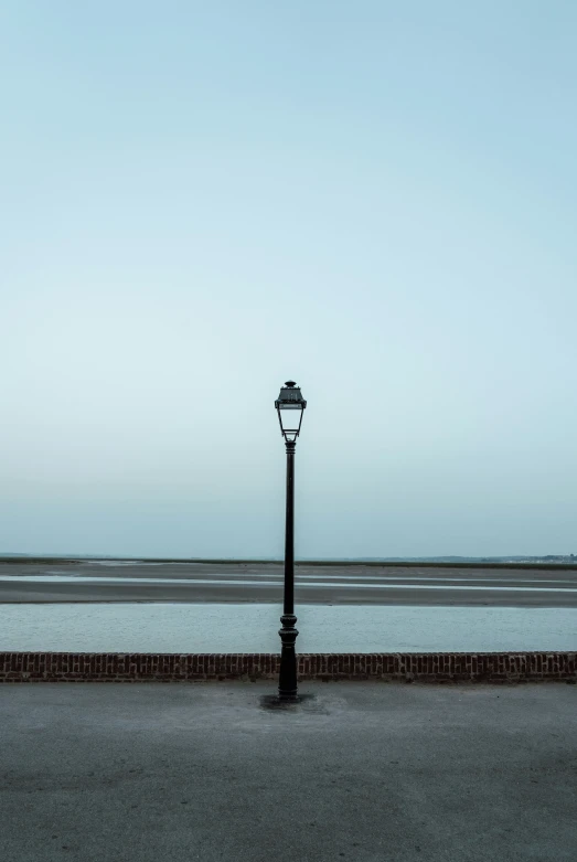 a street light sitting next to a brick wall