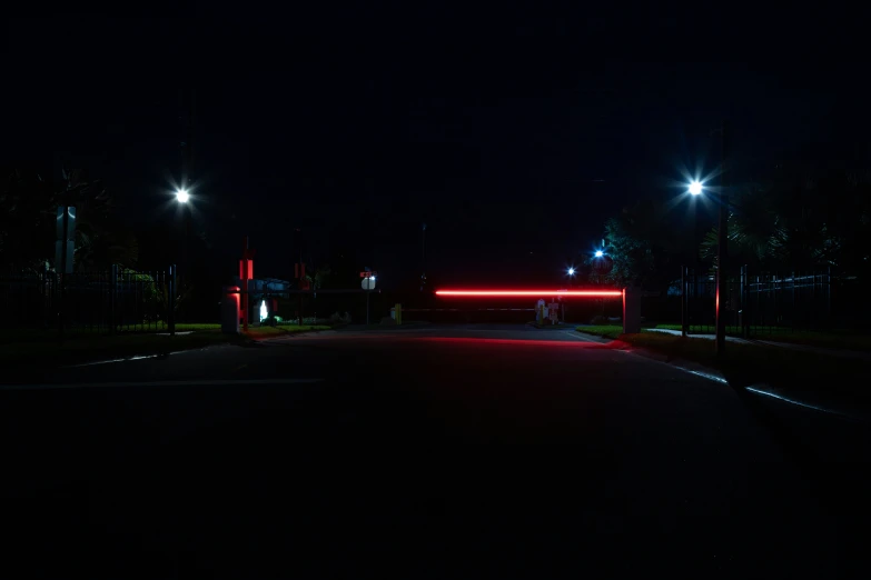 a red light at night shines on a black street