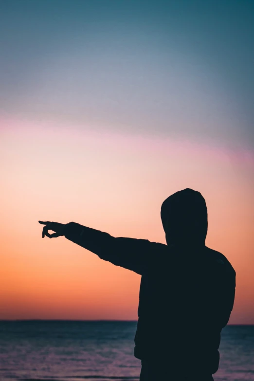 a man pointing his finger toward the horizon