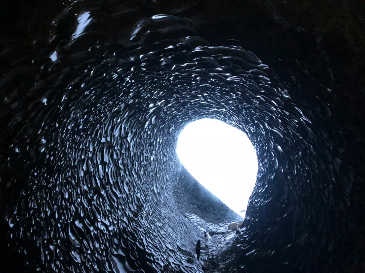 a man on a surf board riding inside a dark tunnel