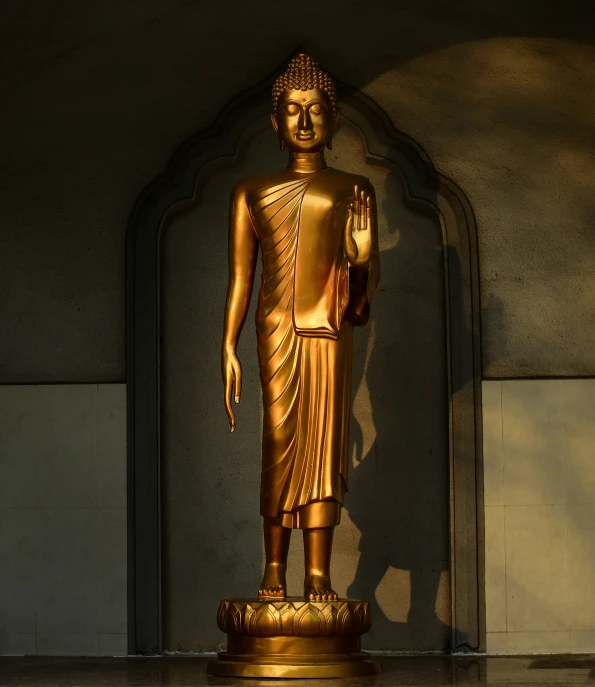 a gold buddha statue in a dimly lit room