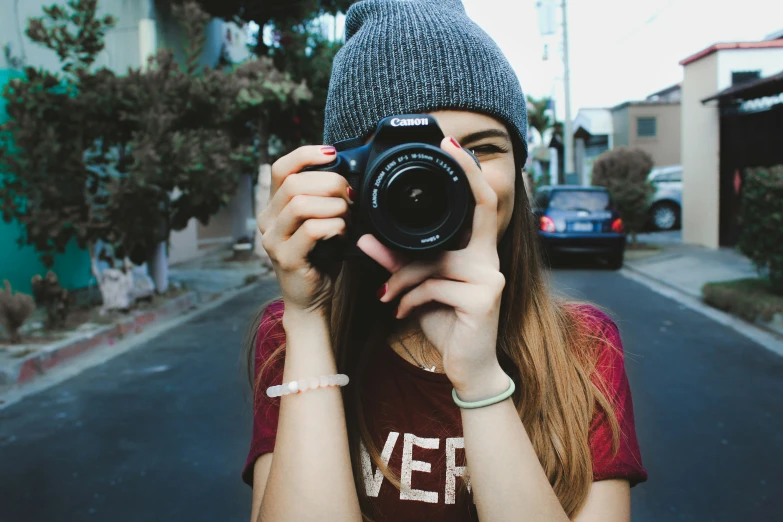 a girl in a red shirt taking a po with a camera
