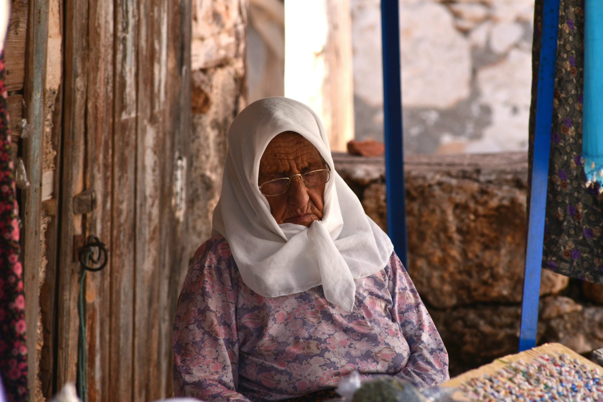 an elderly woman in the desert next to her home