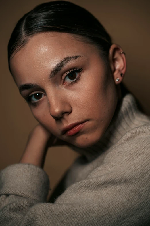 a woman wearing earrings, looking to the side with a concerned look