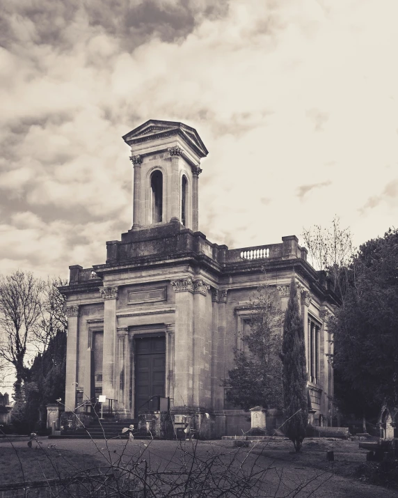 a church tower is surrounded by plants and a cloudy sky