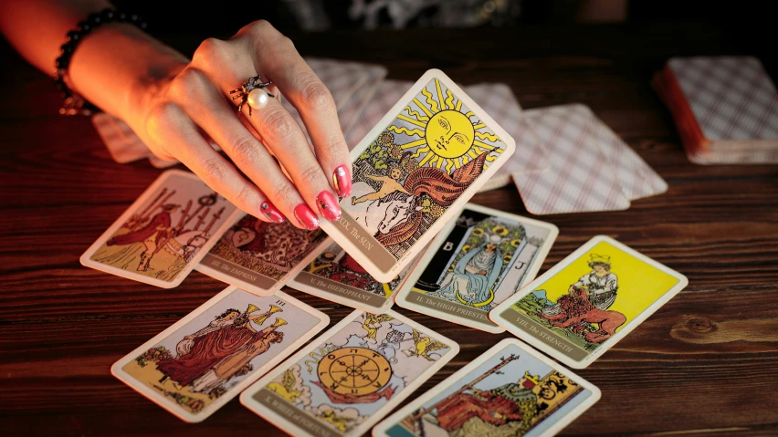 an elegant woman holding six deck cards on the table