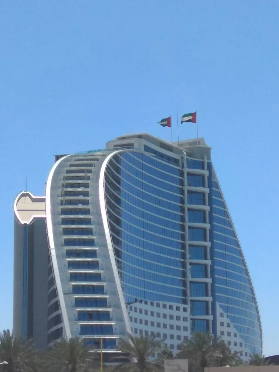 a large glass building is behind a beach