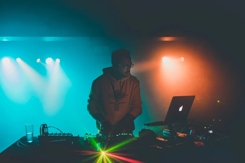 a person standing in front of a laptop on a desk with many bright lights