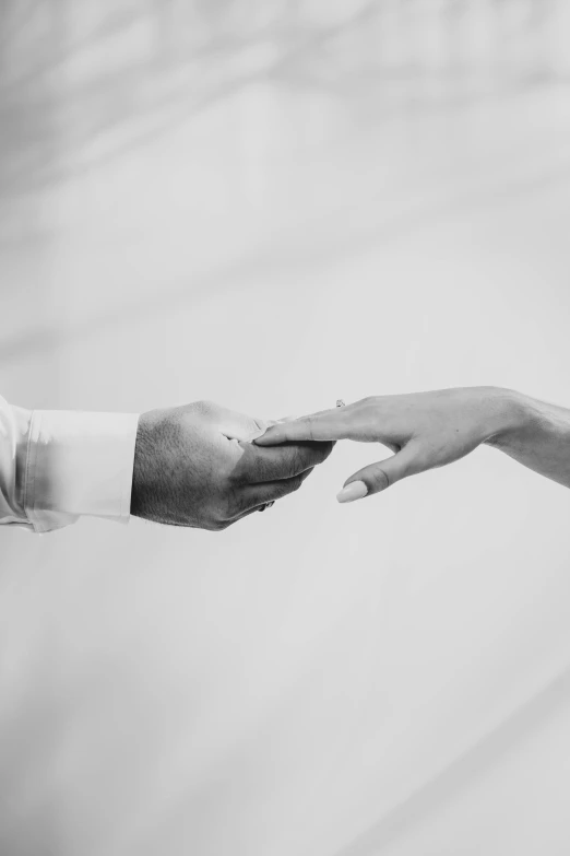 two people reaching out to each other for a piece of bread