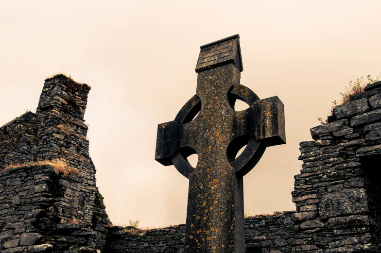 a large cross is seen in front of an old building