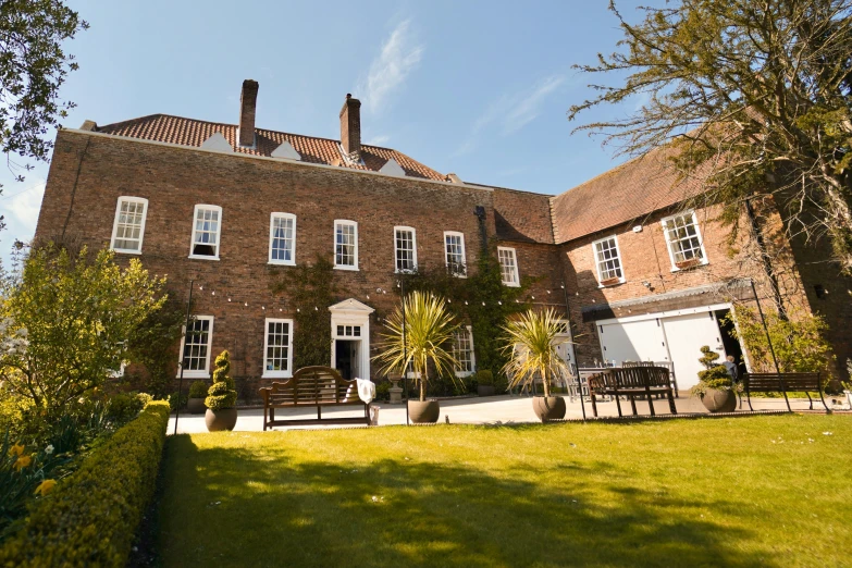 a large red brick building has some windows and white shutters