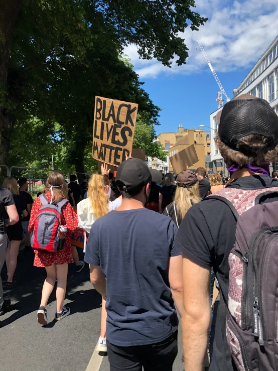 a group of people walking down the street in the sun