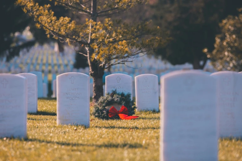 wreath laying in front of some graves at the cemetary