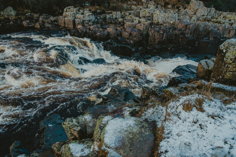 an image of a river flowing between two large rocks