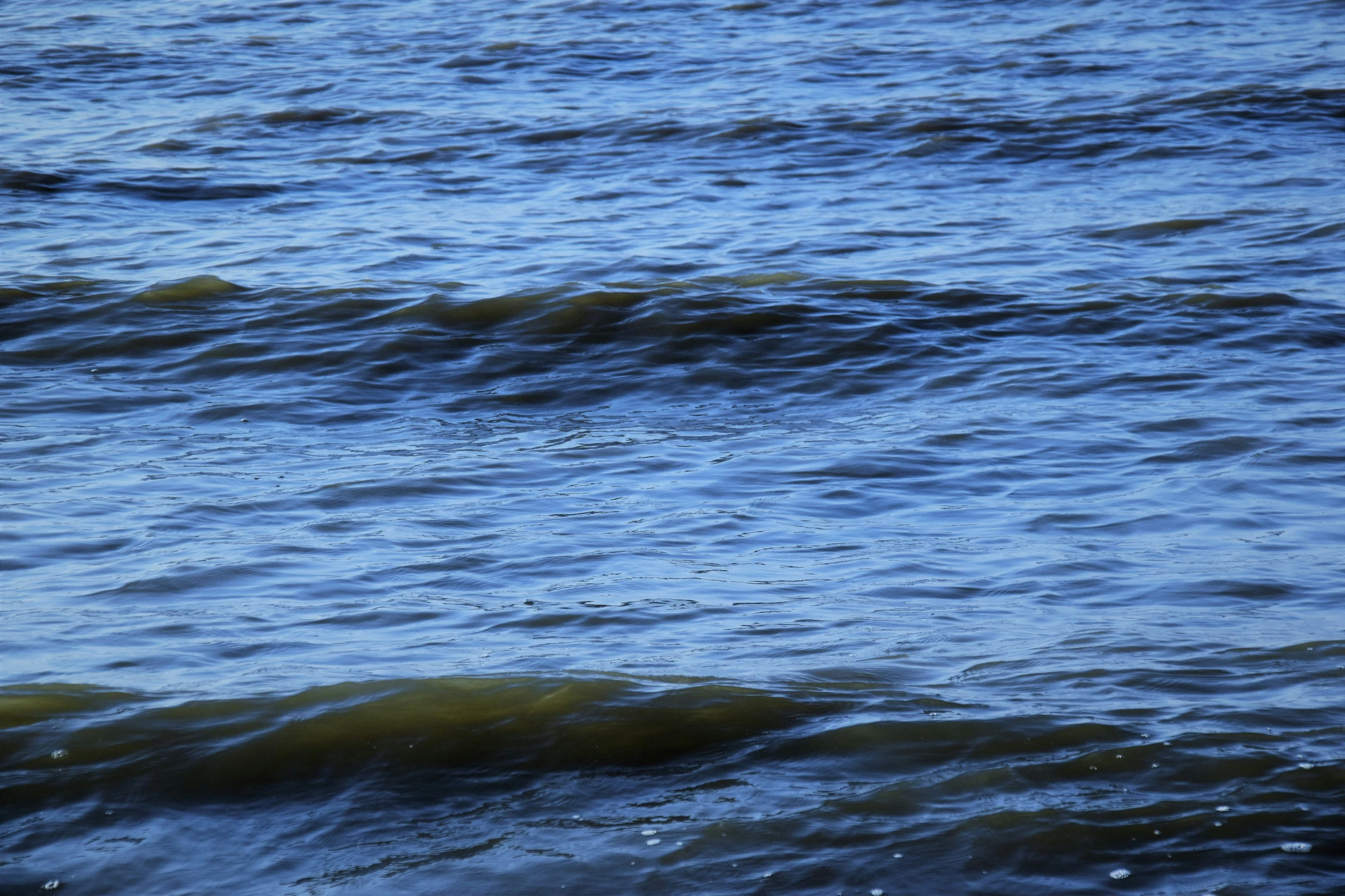 an orange buoy in the ocean with choppy waves