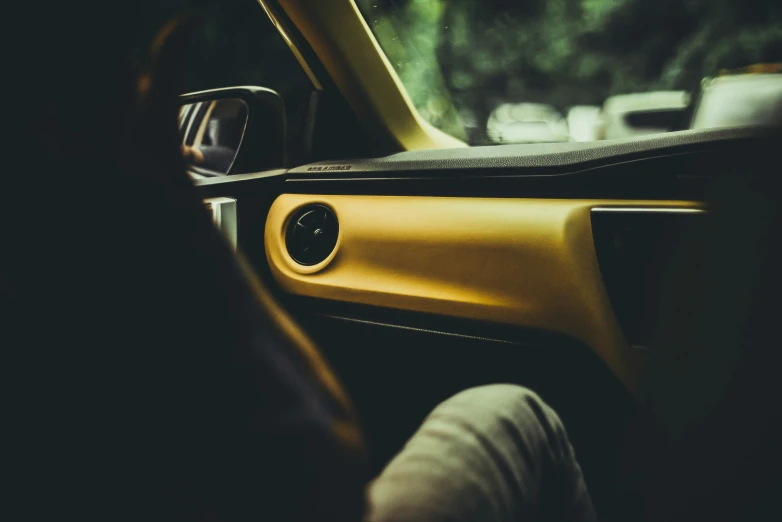 a person sitting in their car looking at soing in the passenger seat