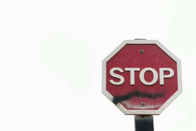 a red stop sign sitting on top of a metal pole