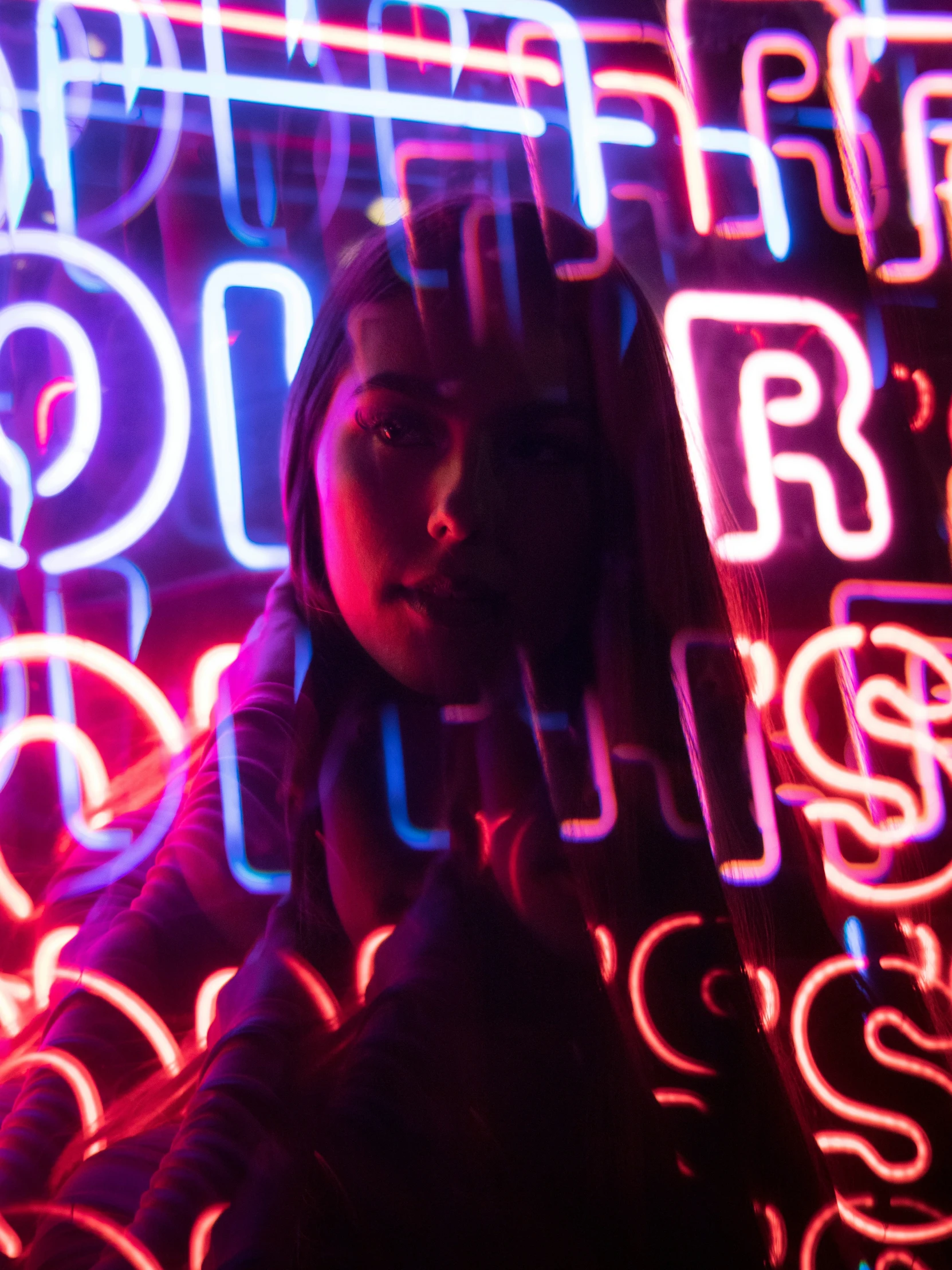 a woman sitting in front of neon signs with numbers around her