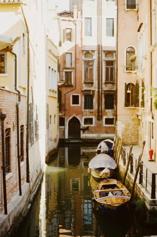 three boats parked on the side of a canal