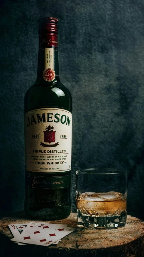 a bottle of jameson sits next to a glass of whiskey