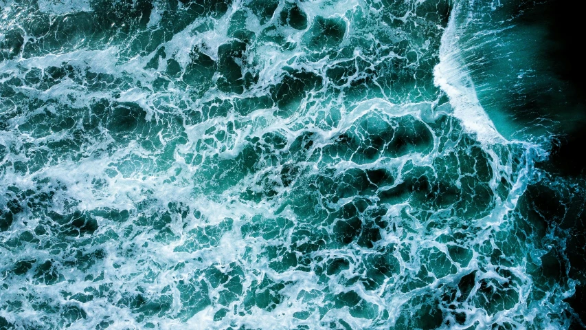 a wave is crashing onto the sandy shore