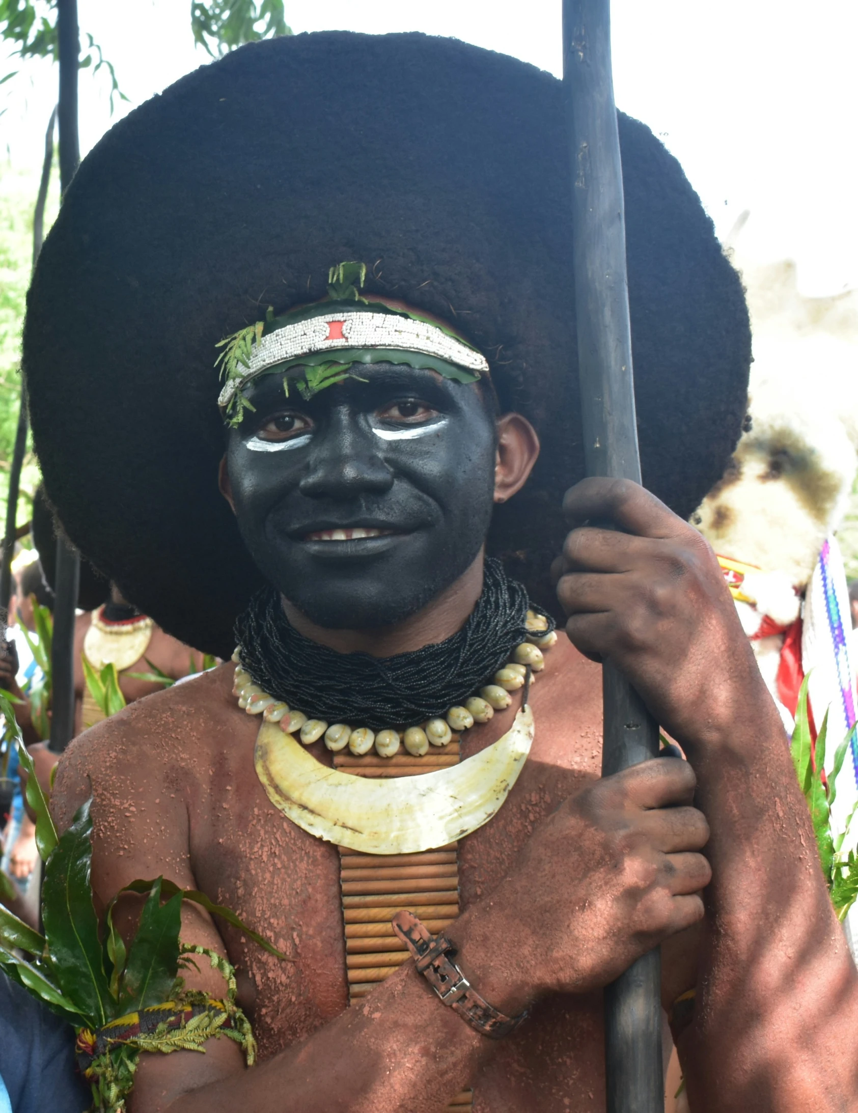 a man with makeup is carrying a stick