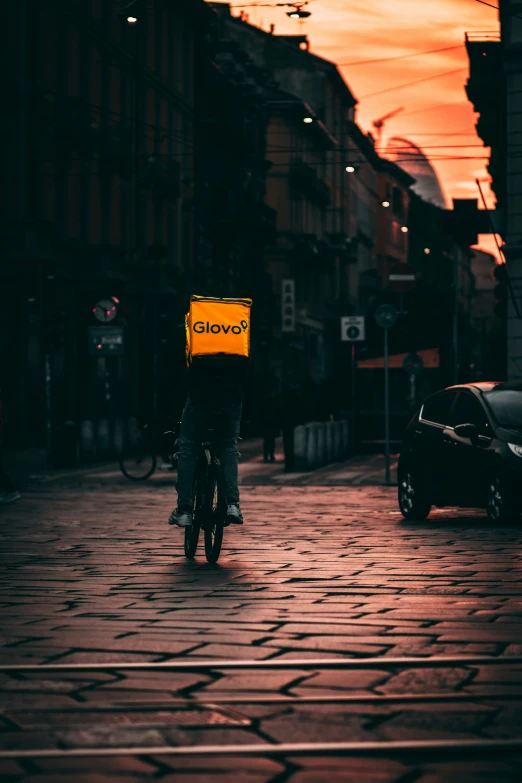 the man is riding his bike with a box on his head