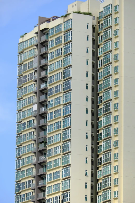 a tall beige building with multiple floors and balconies