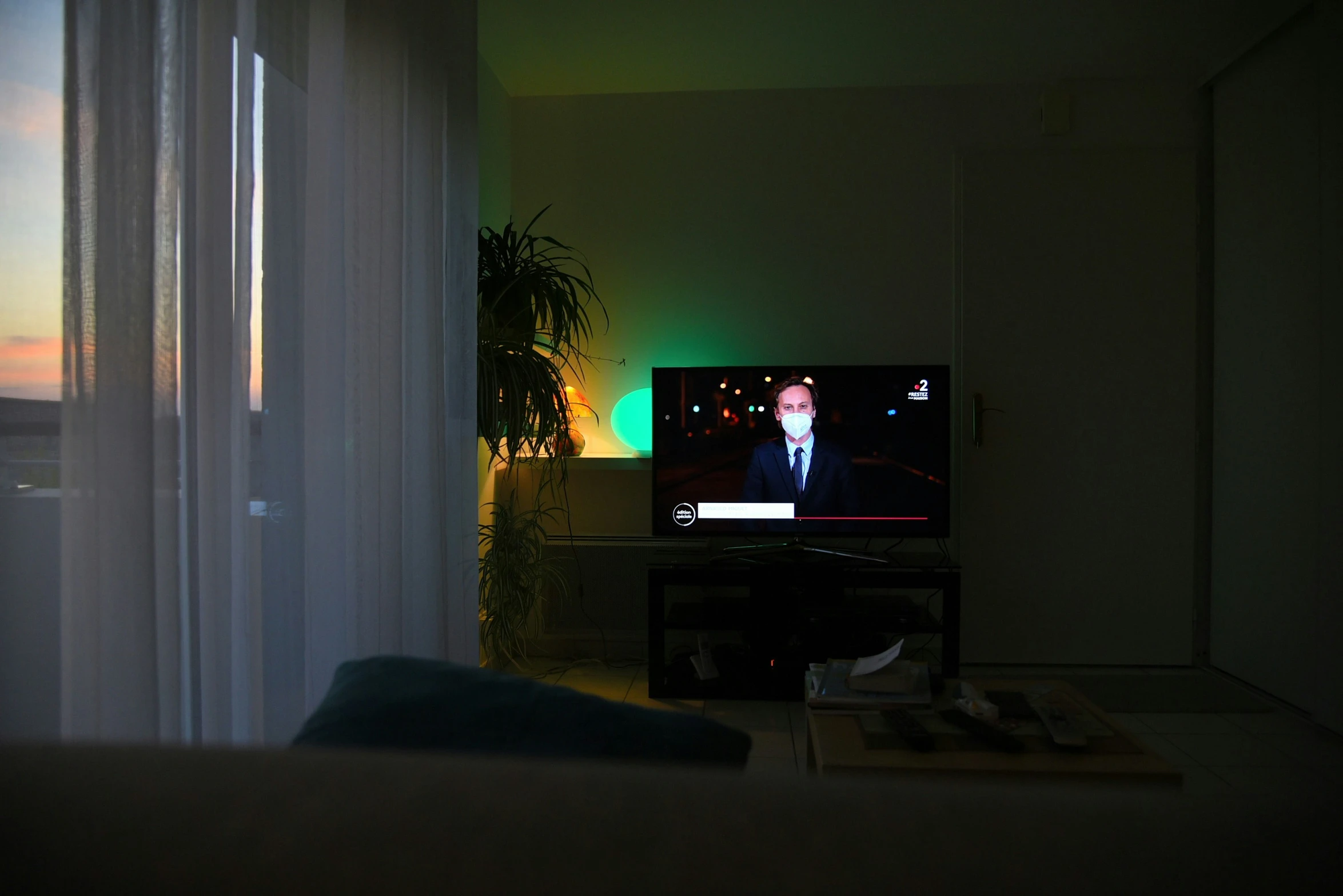 a television set sitting in a living room with people on it