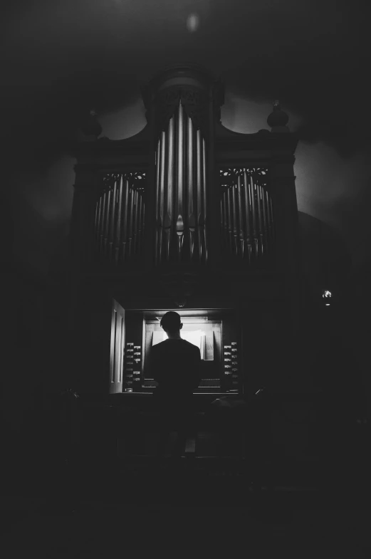 a man standing in front of a pipe organ