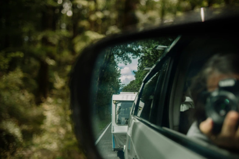 a woman taking a po in the rearview mirror of a truck