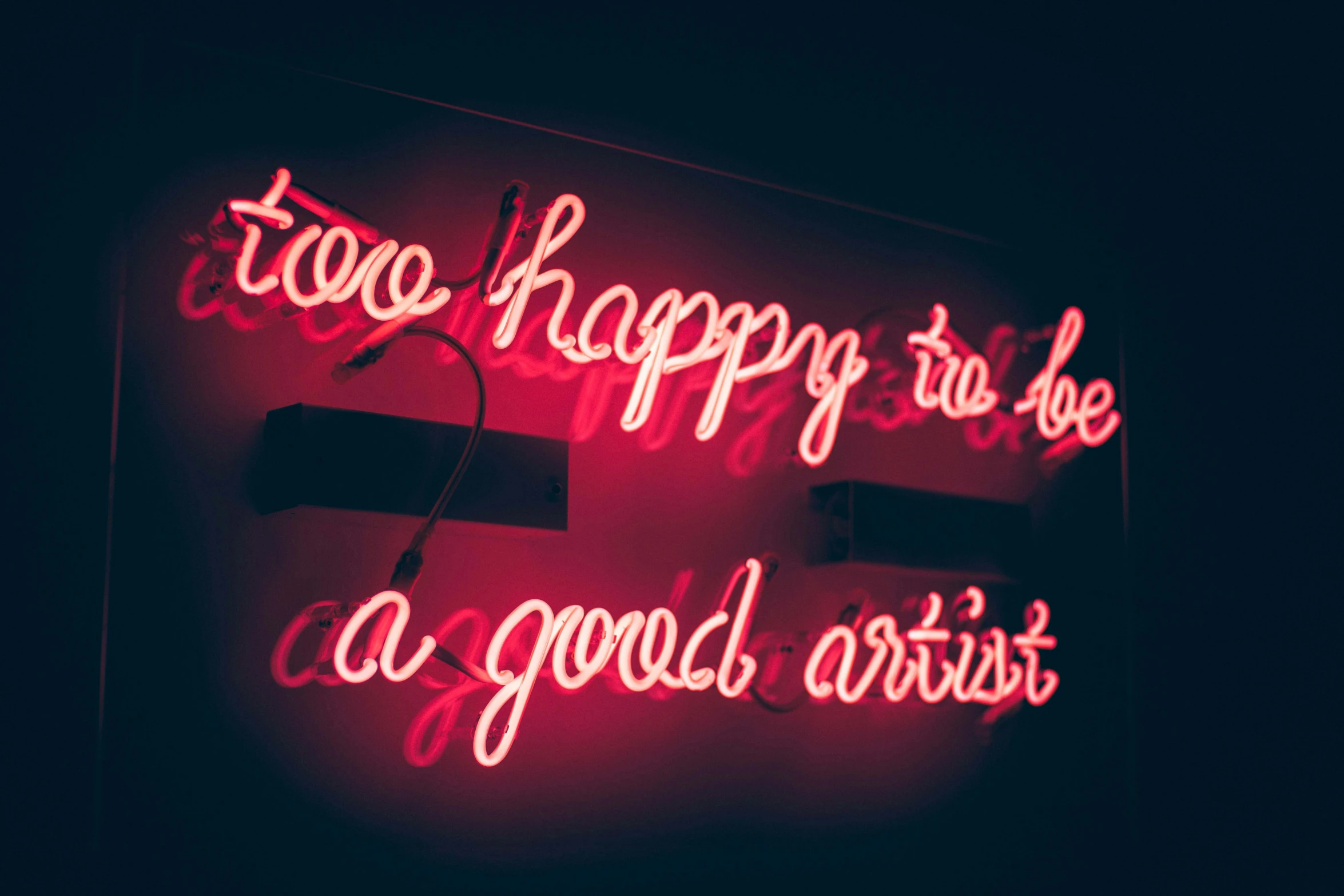 a neon sign that reads, too happy to be a good artist