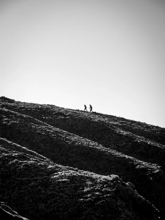 a group of people on a hill, standing and looking down