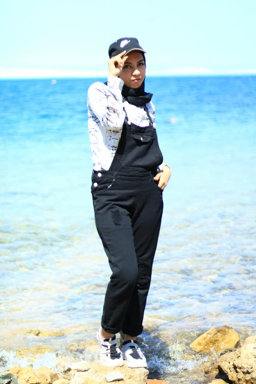 a woman is standing in the water talking on a cellphone