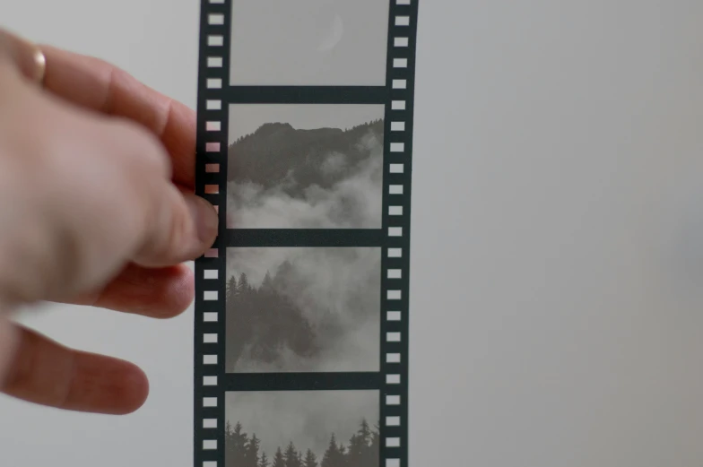 a person holding a film strip near a po