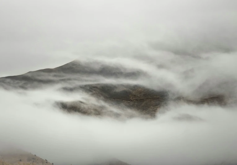 a very steep mountain covered in thick fog