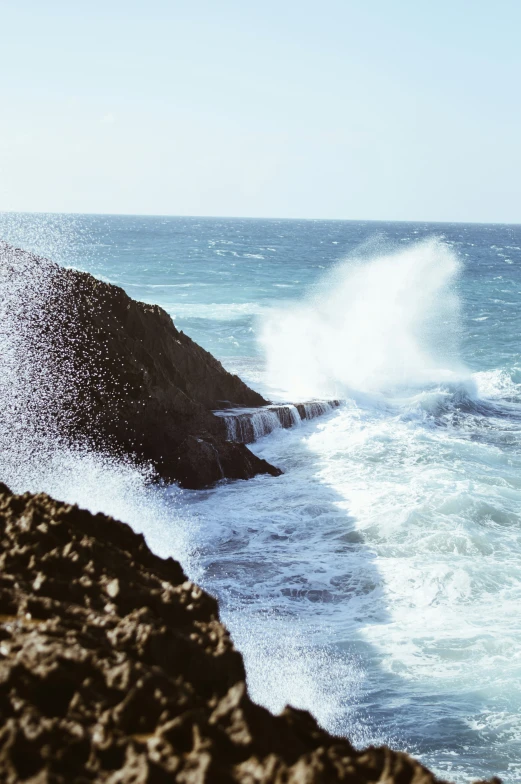 a rocky beach and shore is shown in the sunlight