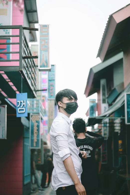 a man with a black mask walking down a street