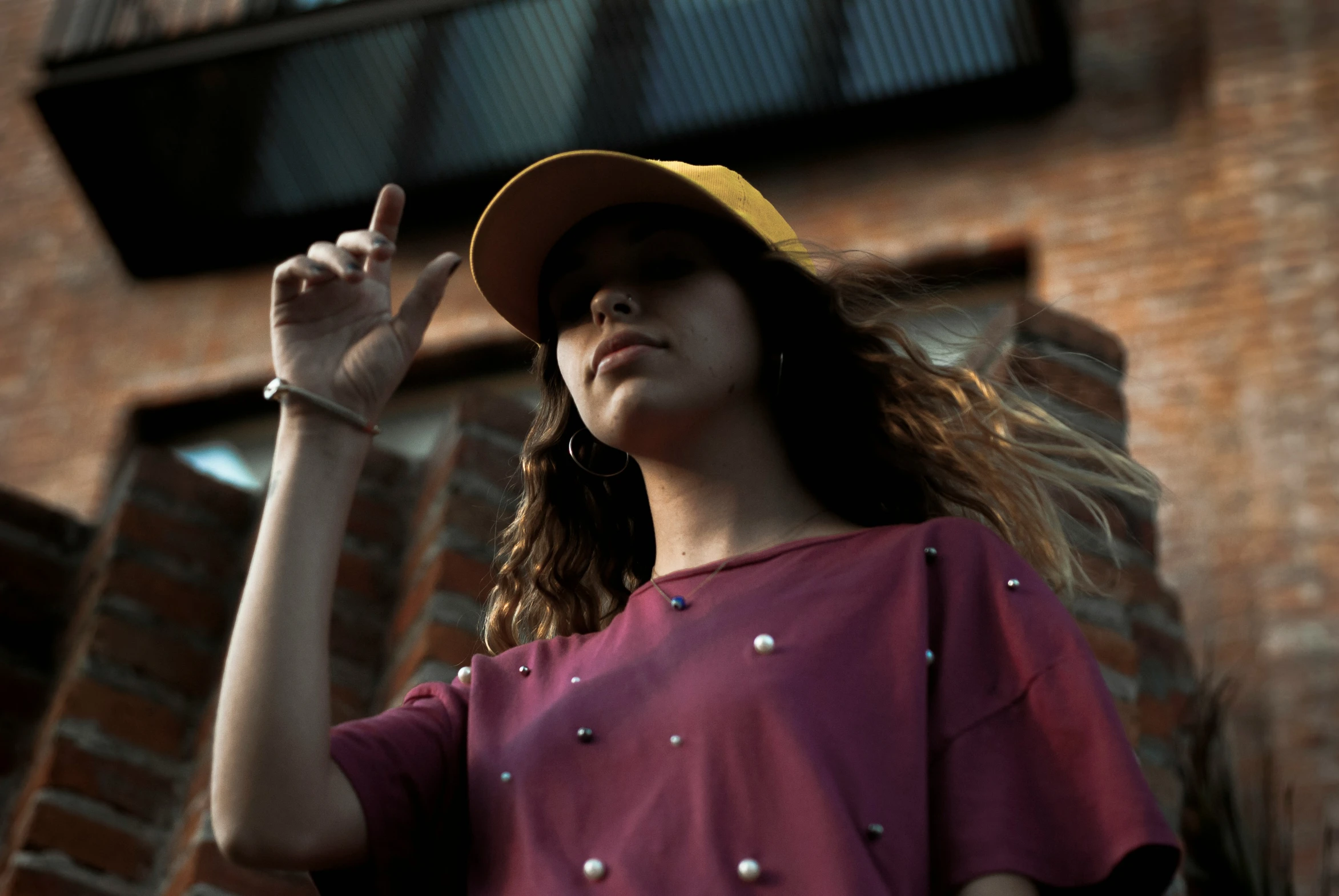 a person wearing a hat and posing with her arm in the air