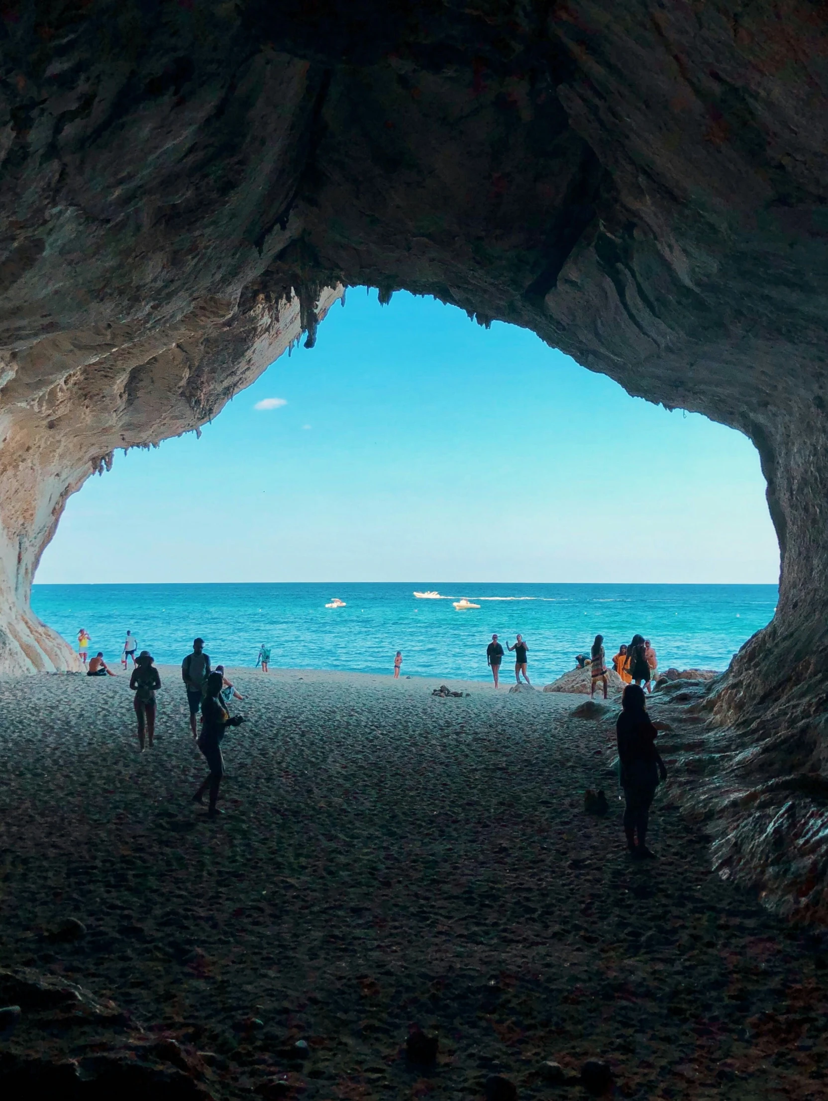 people walking around in between two big rock formations