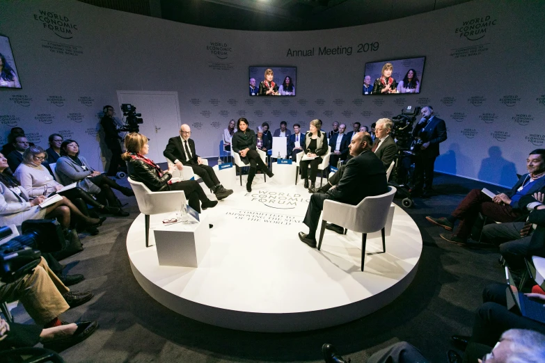 a group of people sitting around tables at a meeting