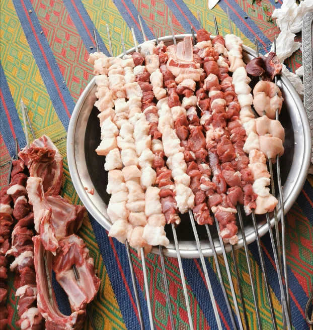 a large group of meat skewers, including meat wrapped in bacon