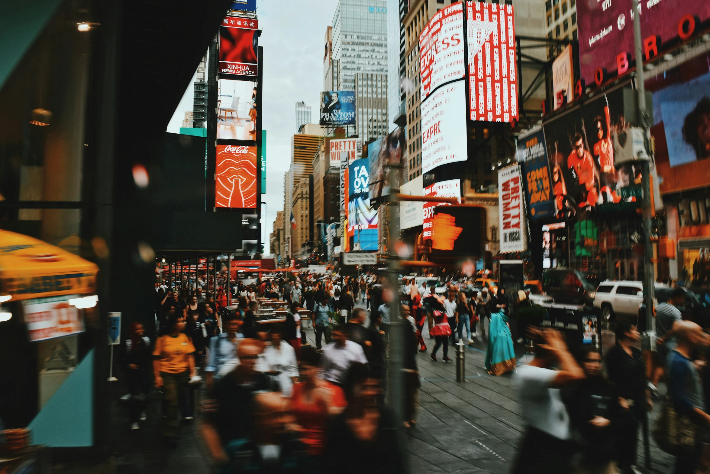 many people on the street in a city with skyscrs