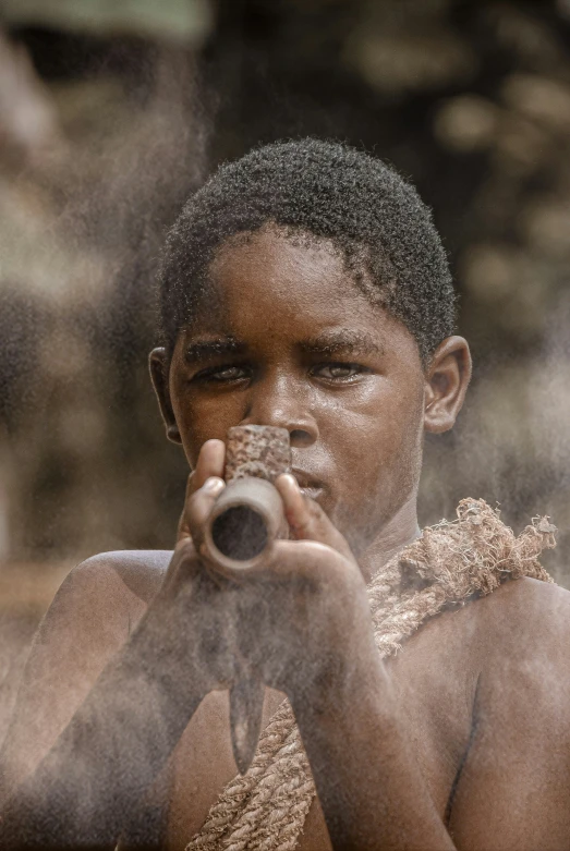 a boy looking through the smoke coming from a pipe