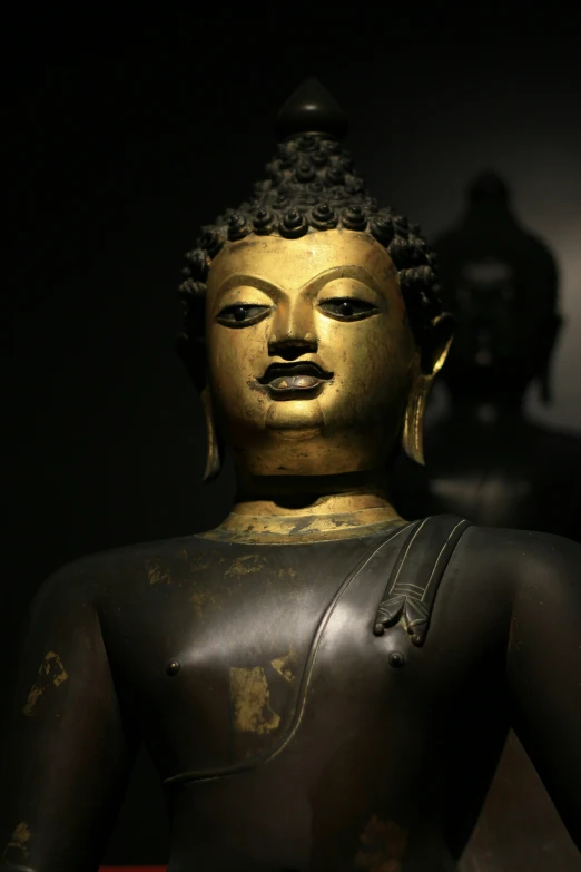 a gold colored statue in a dark room