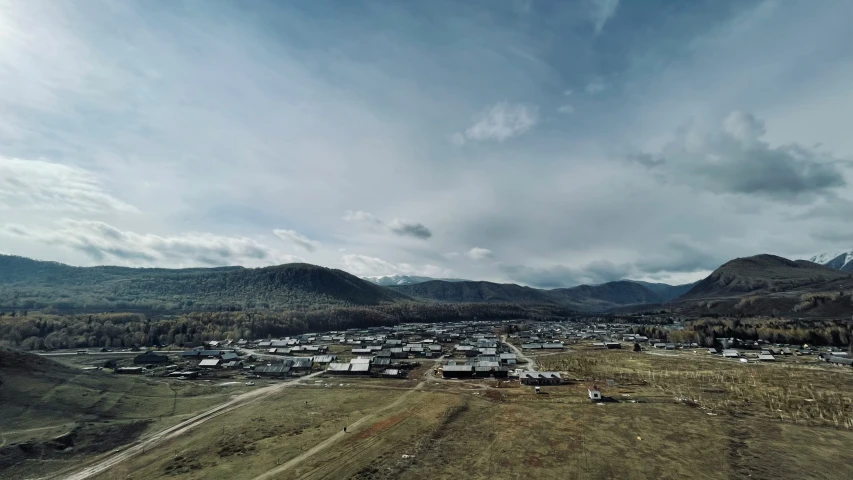 the landscape is cloudy over the village and hill