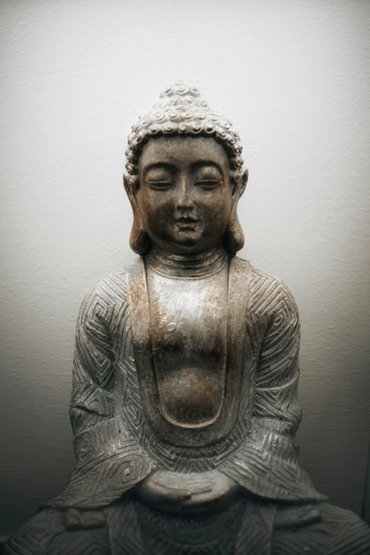 a buddha statue in white is sitting on the ground